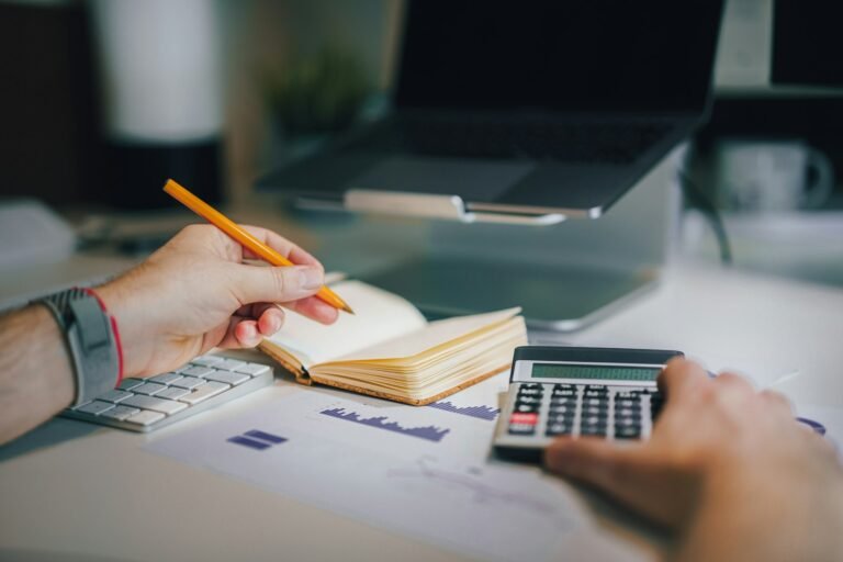 Calculator and financial papers on a desk for budgeting pitch deck design cost